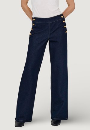 Pantalones de mezclilla de pernera ancha en azul oscuro con detalles de botones dorados en el frente y costuras en contraste. Textura suave y cintura alta.