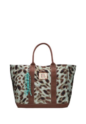 Grote tote tas met bruin en beige luipaardprint, bruine handvatten en een klein bloemenpatch aan de voorkant, met blauwe kralenkwastdecoratie.