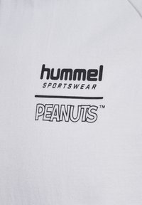 Hvid bomulds t-shirt med "hummel" og "PEANUTS" logoer i sort tryk. Blød tekstur med et klassisk crew neck design.