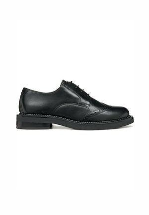 Elegante scarpa Oxford in pelle nera con finitura liscia, dettagli brogue, chiusura con lacci e suola in gomma leggermente sollevata.