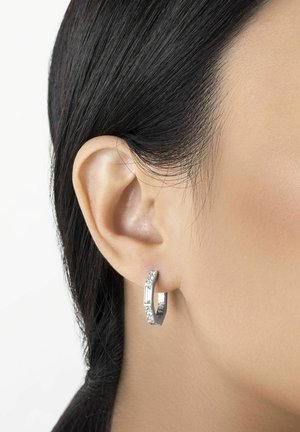 Silver hoopörhänge med en böjd design, som har en rektangulär accent och infällda klara stenar för textur och detaljer.