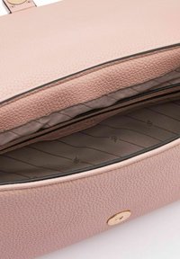 Roze leren tas met textuur en een ritsopening, voorzien van een beige gevoerde binnenkant met subtiele patronen en een gouden hardwareaccent.