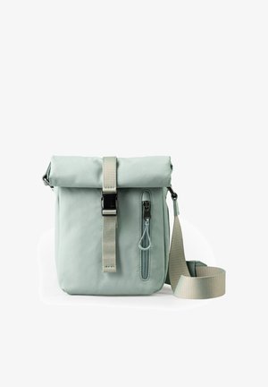 Lichtgroene crossbodytas met opgerolde bovenkant, verticale ritszak aan de voorkant en verstelbare riem, afgebeeld op een witte achtergrond.