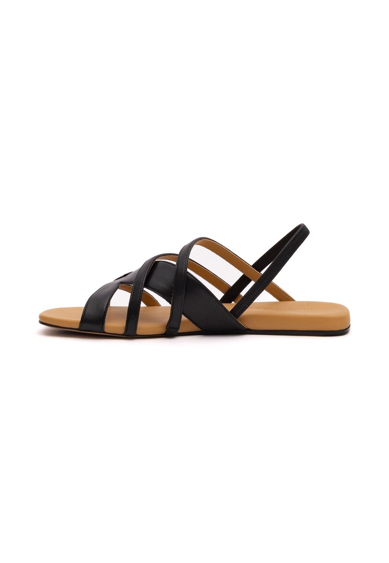 Schwarze Ledersandalen mit mehreren überkreuzten Riemen, flacher Sohle und glattem, braunem Fußbett. Einfaches und offenes Design für Atmungsaktivität.
