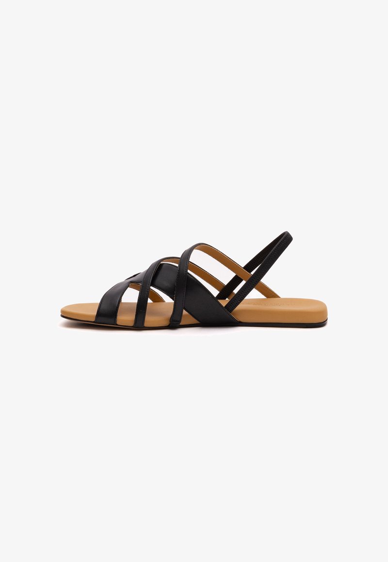 Schwarze Ledersandalen mit mehreren überkreuzten Riemen, flacher Sohle und glattem, braunem Fußbett. Einfaches und offenes Design für Atmungsaktivität.