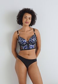 Lettisk bh med blå og svart dyreprint, med støtte fra underwire, gjennomsiktige sider og justerbare stropper. Svart matchende undertøy. Glatt tekstur.
