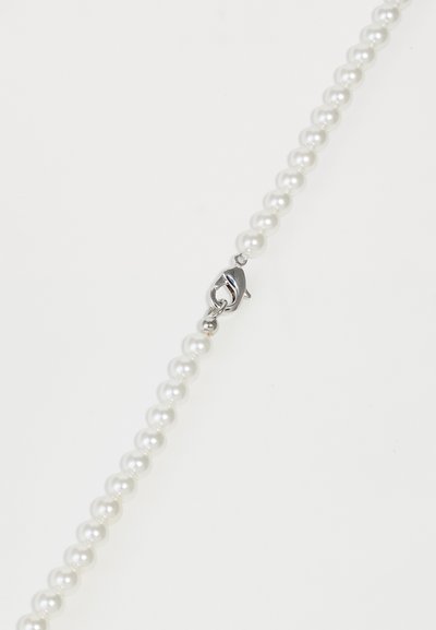 Un collier de perles rondes blanches avec un fermoir en argent en forme de homard sur un fond blanc.