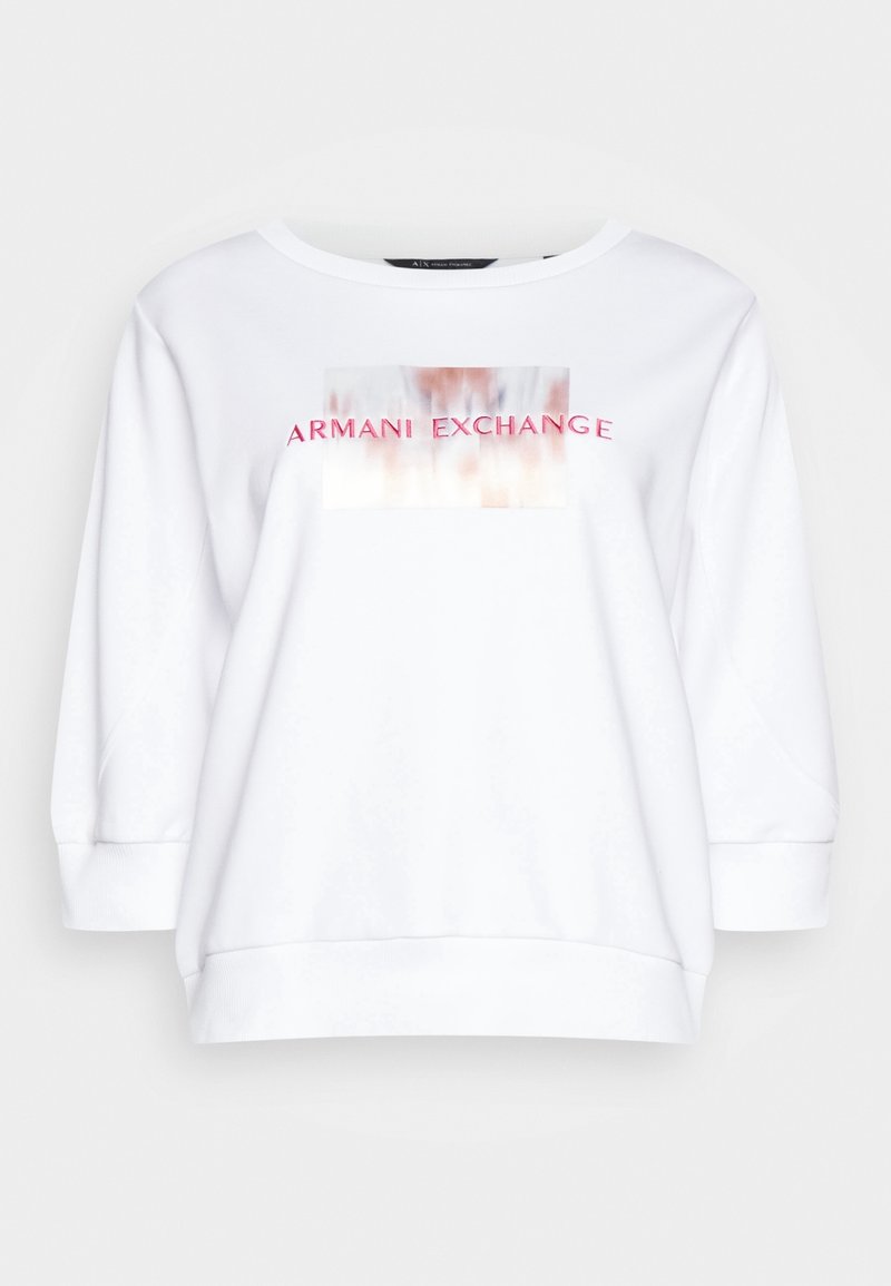 Sweat-shirt blanc à manches longues avec col rond et texte rose "Armani Exchange" sur un motif rectangulaire flou sur la poitrine.