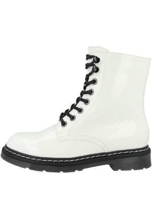 Botte montante en cuir blanc avec lacets noirs et semelle épaisse noire avec coutures blanches sur le pourtour.