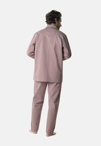 Ensemble de pyjama multicolore avec un motif géométrique, fabriqué en tissu doux, comprenant une chemise à boutons à manches longues et un pantalon assorti.
