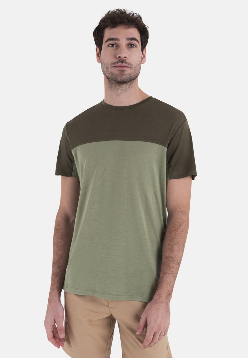 T-shirt a maniche corte con design bicolore, parte superiore verde scuro e parte inferiore verde chiaro, realizzato in tessuto morbido.