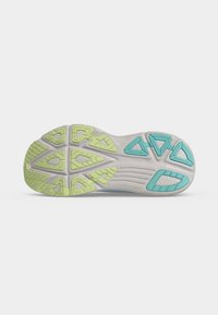 Semelle de chaussure à base blanche présentant des motifs d'adhérence en caoutchouc verts et bleus ainsi que des rainures de flexion.