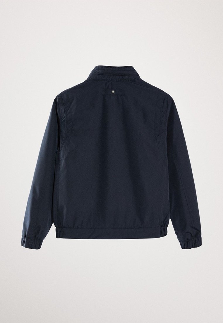 Veste légère bleu marine foncé à manches longues, poignets et taille élastiques, vue de dos sur fond uni.