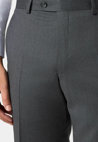 Grijze op maat gemaakte broeken van gladde stof, met een voornaad, subtiele textuur en een enkele knoopsluiting bij de taille.