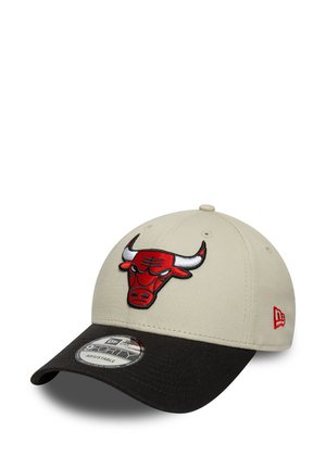 Beige baseballcap met een zwarte rand. Heeft een rood stierenlogo geborduurd aan de voorkant. Verstelbare strap aan de achterkant voor een goede pasvorm.