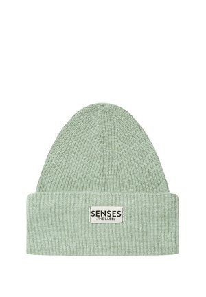 Hellgrüne gerippte Strickmütze mit umgeschlagenem Rand und einem weißen Etikett, das "SENSES THE LABEL" in schwarzen Buchstaben zeigt.