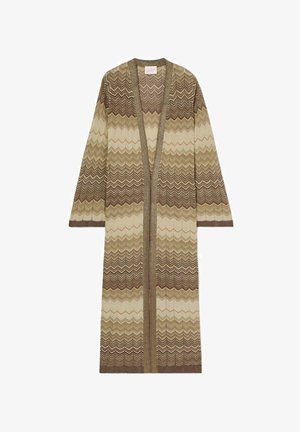 Long cardigan en maille avec motif zigzag dans des tons marron, beige et crème, devant ouvert et manches longues.