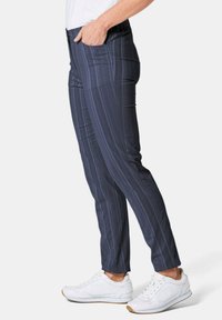 Marine gestreepte broek met een rekbare tailleband, zijzakken en een slim fit, gecombineerd met witte sportschoenen. Soepele stofstructuur.