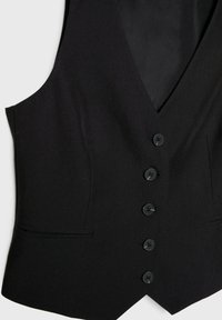 Gilet noir formel avec cinq boutons sur le devant et deux petites poches passepoilées horizontales de chaque côté.