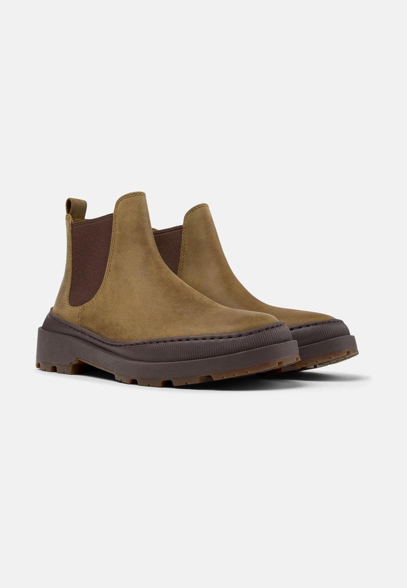 Botas Chelsea de ante marrón con paneles laterales elásticos, punta redondeada y una suela de goma gruesa y texturada para un mejor agarre.