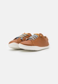 Scarpe in pelle marrone con lacci blu e arancio, progettate con un profilo basso, suola in gomma bianca e dettagli di cucitura minimi.