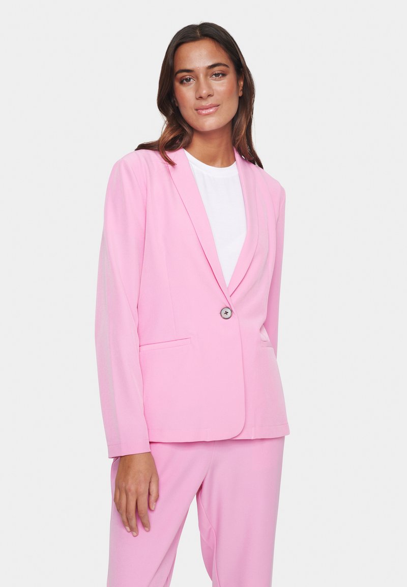 Růžový blazer s dlouhými rukávy, s klopami, zapínání na jeden knoflík a dvěma předními kapsami. Hladká tkanina, součást koordinovaného outfitu.