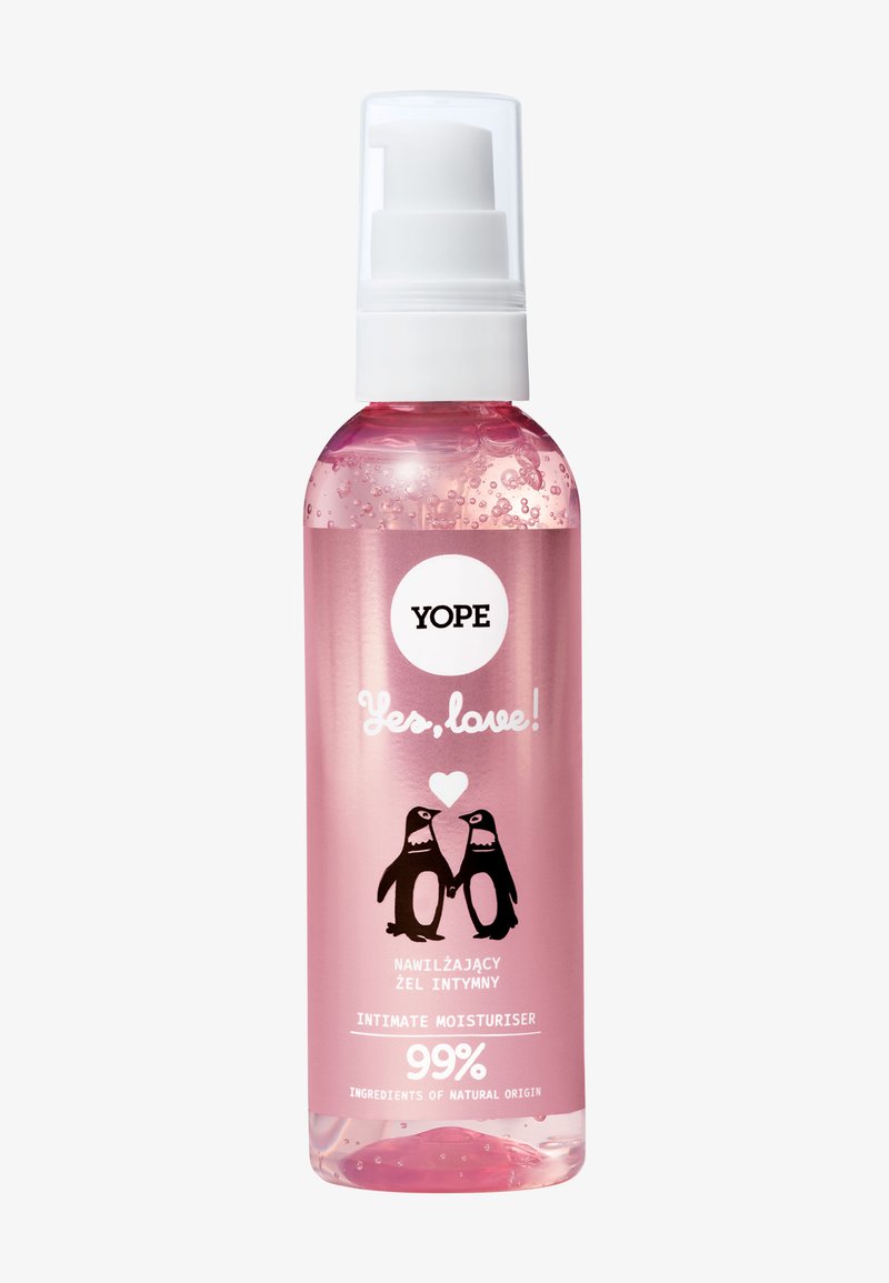 Bouteille en plastique rose avec un distributeur à pompe transparent ; présente des illustrations de pingouins noirs et le texte « Oui, l'amour ! Hydratant intime », 99 % naturel.