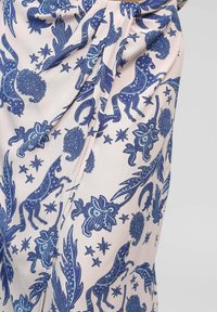 Tissu rose orné de motifs bleus représentant des licornes, des fleurs et des étoiles. Texture lisse avec des détails de plis pour un design supplémentaire.