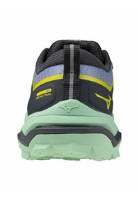 Zapatilla de trail running con un upper negro y gris, suela verde claro, acentos amarillos y un perfil texturizado; cuenta con una lengüeta en la parte trasera.