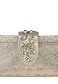 Clutch metálico dorado con superficie texturizada, que presenta un cierre decorativo adornado con piedras claras y doradas de diferentes tamaños. Logo grabado en la parte inferior.