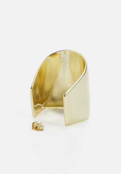 Gold-tone metal cuff bracelet with a smooth, shiny surface and curved design. Includes a small matching stud earring.