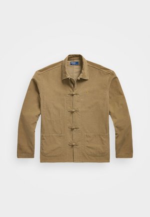 Tan cotton jacket featuring a mandarin collar, front toggle closure, and two large patch pockets on the front.