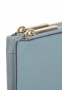 Lichtblauw ritszakje van gestructureerd synthetisch materiaal, met gouden hardware en stiksel details langs de randen.