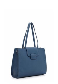 Sac à main en cuir bleu avec deux bretelles et une fermeture à rabat à l'avant, debout sur un fond blanc.