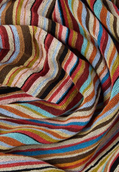 Bunte gestrickte Decke mit kräftigen Streifen in Rot-, Blau-, Braun-, Pink- und Cremetönen, die eine strukturierte, weiche Oberfläche hat.