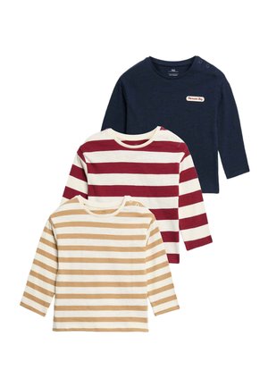Tre langærmede babytrøjer med skulderknapper; en marineblå med et mærke, en hvid med røde striber, og en hvid med beige striber.