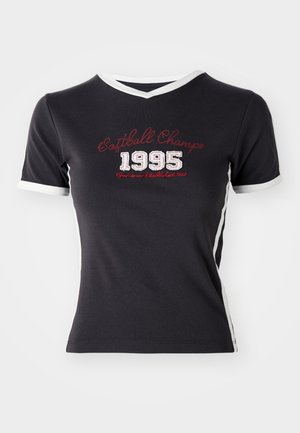 Melnas kokvilnas T-krekls ar īsām piedurknēm, baltu apdari un vintage stila uzrakstu "Softball Champ 1995" sarkanā un baltā krāsā.