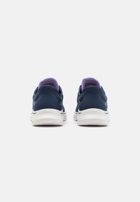Navy blue sneakers with a smooth texture, white soles, and a purple accent at the collar. Features a low-top design for easy wear.