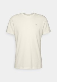 Kortærmet t-shirt med rund hals i off-white bomuld, med et lille broderet design på venstre bryst, glat tekstur.