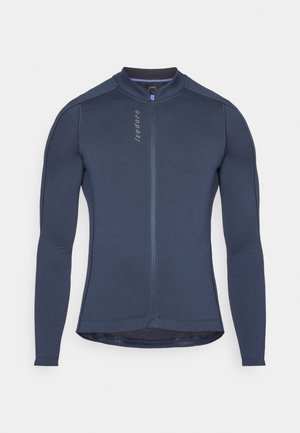 Dlouhý rukáv cyklistický dres v námořnické modré, s plným předním zipem, texturovanou tkaninou a reflexními detaily. Vysoký límec s ergonomickými švy.