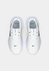 Λευκά αθλητικά παπούτσια με επάνω μέρος από δίχτυ, κορδόνια και καουτσούκ σόλες. Διαθέτουν μαύρο σήμα Nike και τη γράφη "COMFORT" στη γλώσσα.