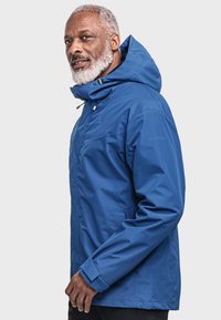 Blaue wasserdichte Jacke mit hohem Kragen und verstellbarem Kapuzen. Verfügt über zwei Seitentaschen und einen Frontreißverschluss, aus glattem Material gefertigt.