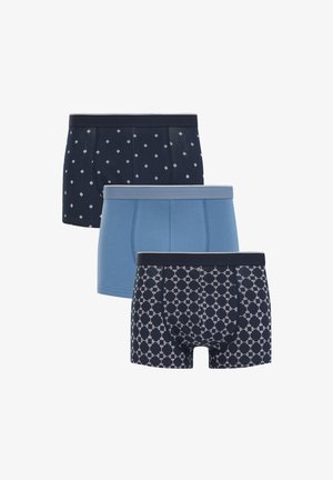 Tre par herreboxershorts i blå nuancer, hvor to par har geometriske mønstre og et par er ensfarvet blå, stablet foran hinanden.