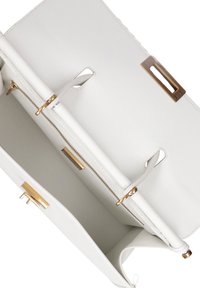 Interno di una borsa in pelle bianca con hardware dorato. Presenta un compartimento con zip e due slot aperti per l'organizzazione. Texture liscia.