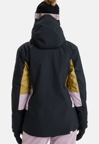 Wasserdichte Jacke mit schwarzem Körper und gelben sowie pinken Akzenten. Enthält eine Kapuze und besteht aus einem strukturierten, strapazierfähigen Material.