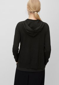 Dark green hoodie in a soft fabric, featuring a large hood, long sleeves, and a front pocket. Smooth texture with simple design lines.