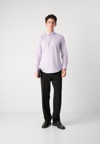 Cămașă button-up de culoare violet deschis cu mâneci lungi, asortată cu pantaloni negri și pantofi negri, ținea un dosar negru într-o mână.