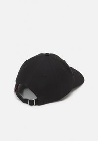 Melna kokvilnas cepure ar izliekto malu, regulējamu lenti aizmugurē un šuvju detaļām. Gluda tekstūra ar bezšuvju dizainu.