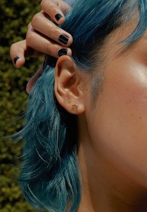 Náušnice s pozláteným povrchom, s textúrovaným obdĺžnikovým dizajnom a malými rhinestone kamienkami; modelka má vlasy po plecia modrej farby.