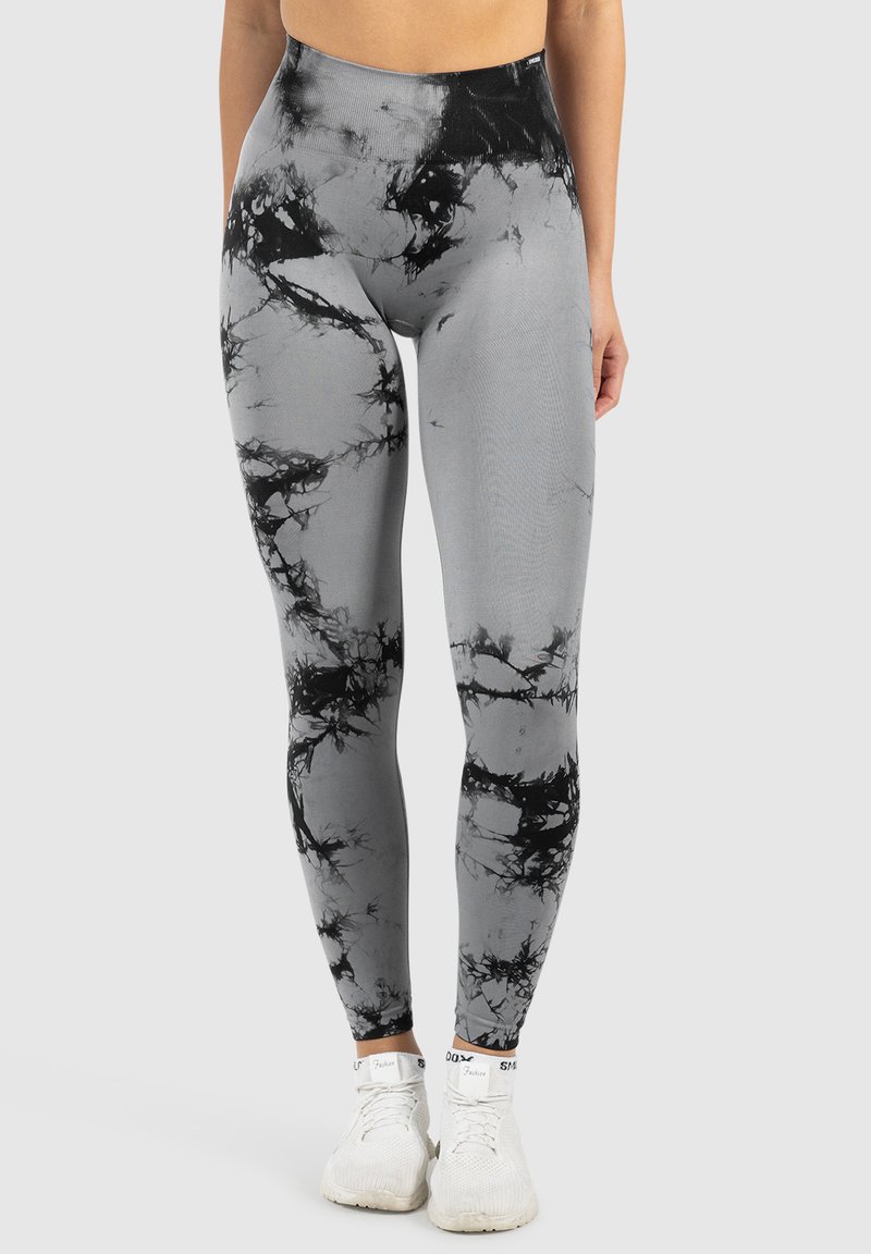 Leggings de patrón de mármol negro y gris con cintura alta, confeccionados en material elástico, diseñados para ajustarse de manera ceñida.